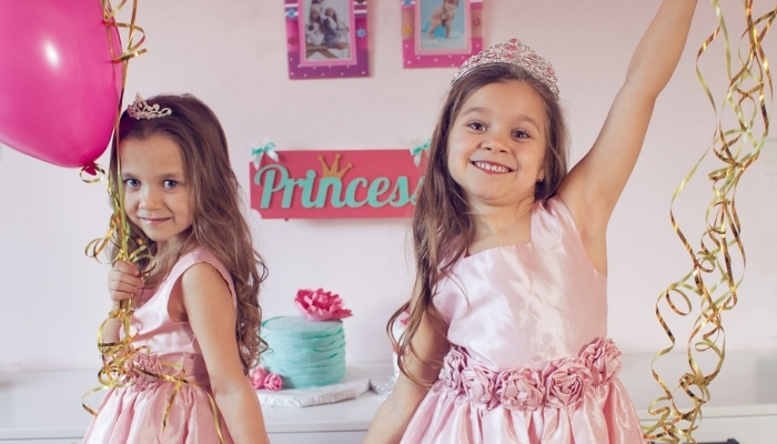 Sisters dressed as princesses for a birthday party.
