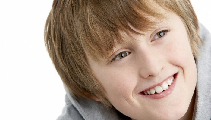 Head shot of an 11-year-old boy with shoulder-length hair and a gray sweatshirt.