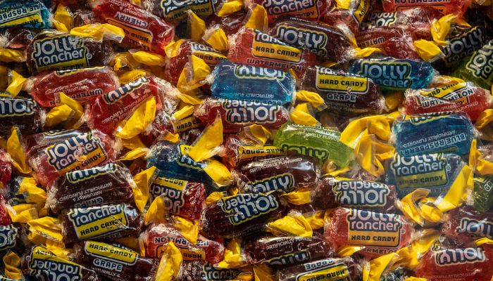 Full-screen shot of colorful Jolly Rancher hard candies still in wrappers.
