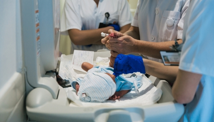 A medical team examining and treating a newborn baby.