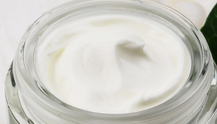 A glass jar of homemade lotion up close.