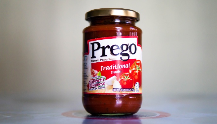 A single jar of Prego spaghetti sauce on a counter.