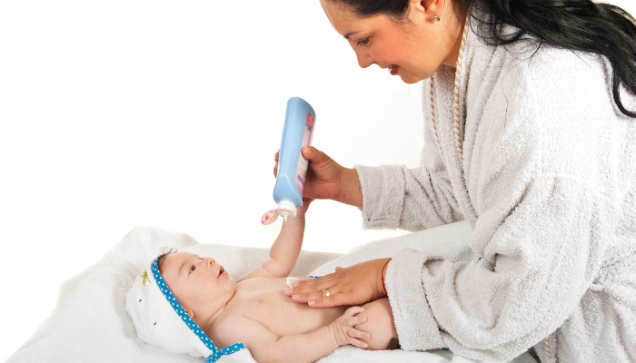 A mother applying baby lotion to her baby for a gentle massage.