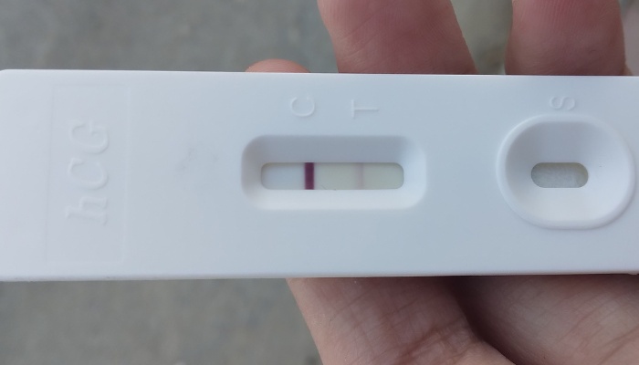 A pregnancy test showing a dark control line and an evaporation line.