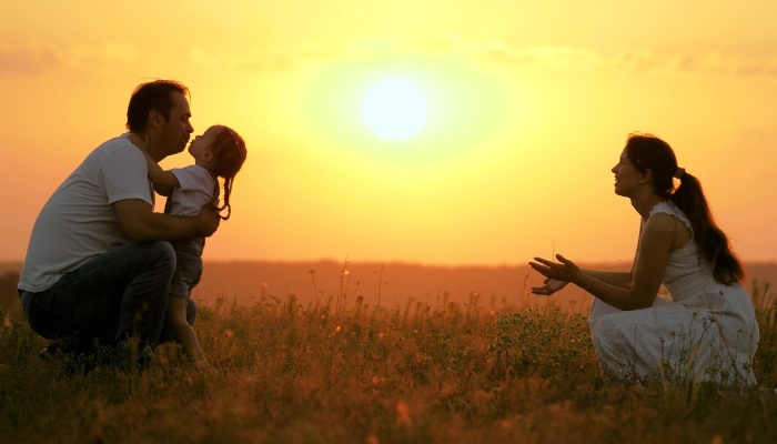 A child choosing to run to father instead of mother with a sunset in the background.