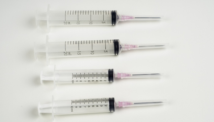 Four empty syringes on a white background.